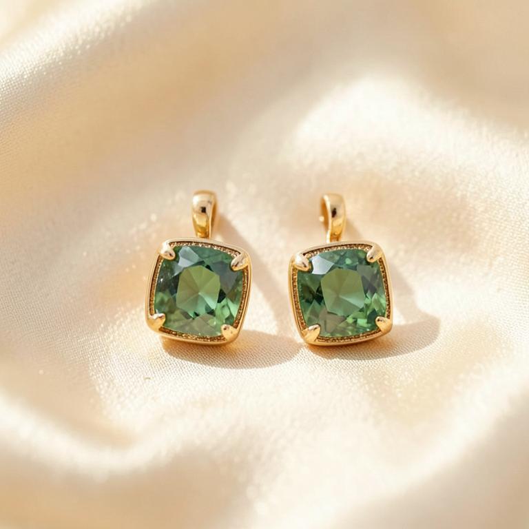 Gold and green gemstone drop earrings on cream silk